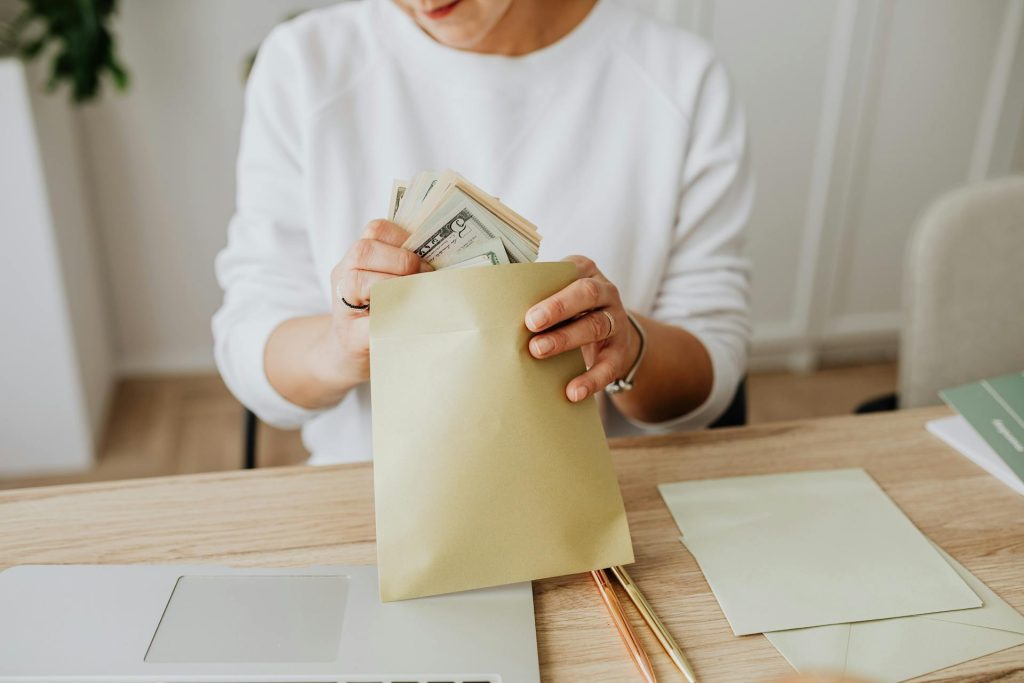 femme qui mets de l argent dans une enveloppe