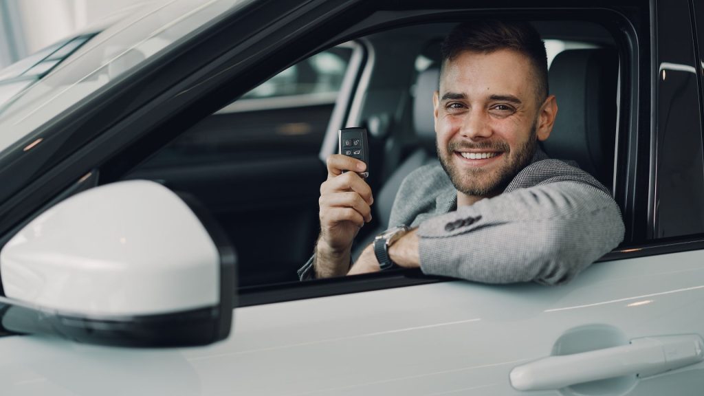 homme dans voiture avec clés dans la main