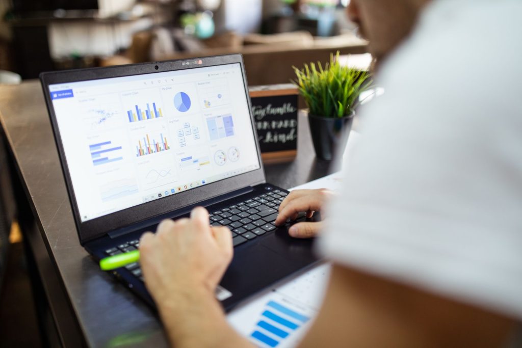 homme devant ordinateur portable avec graphiques